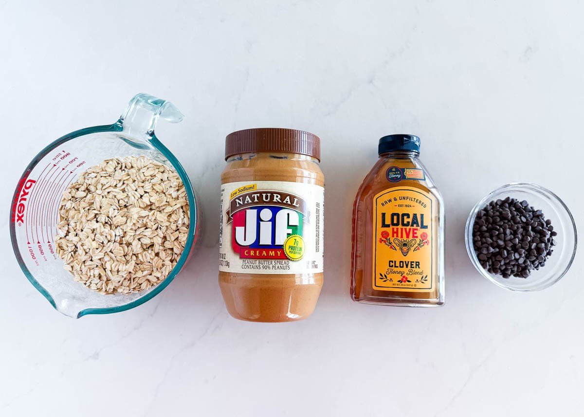 These chewy peanut butter oatmeal bars are an easy no-bake snack, breakfast or healthy dessert made with simple ingredients like peanut butter, oats, and honey! Ingredients for no bake peanut butter oatmeal bars including rolled oats, peanut butter, honey, and mini chocolate chips.