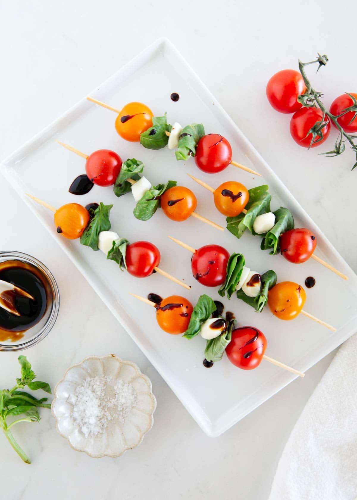 Caprese skewers on a white plate.