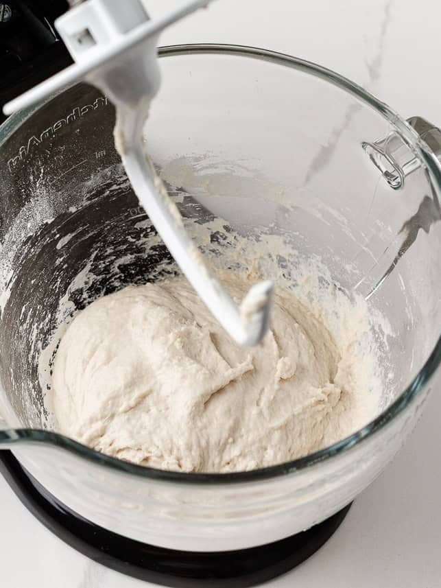 Same day sourdough bread dough after kneading in a stand mixer bowl with the hook attachment visible.