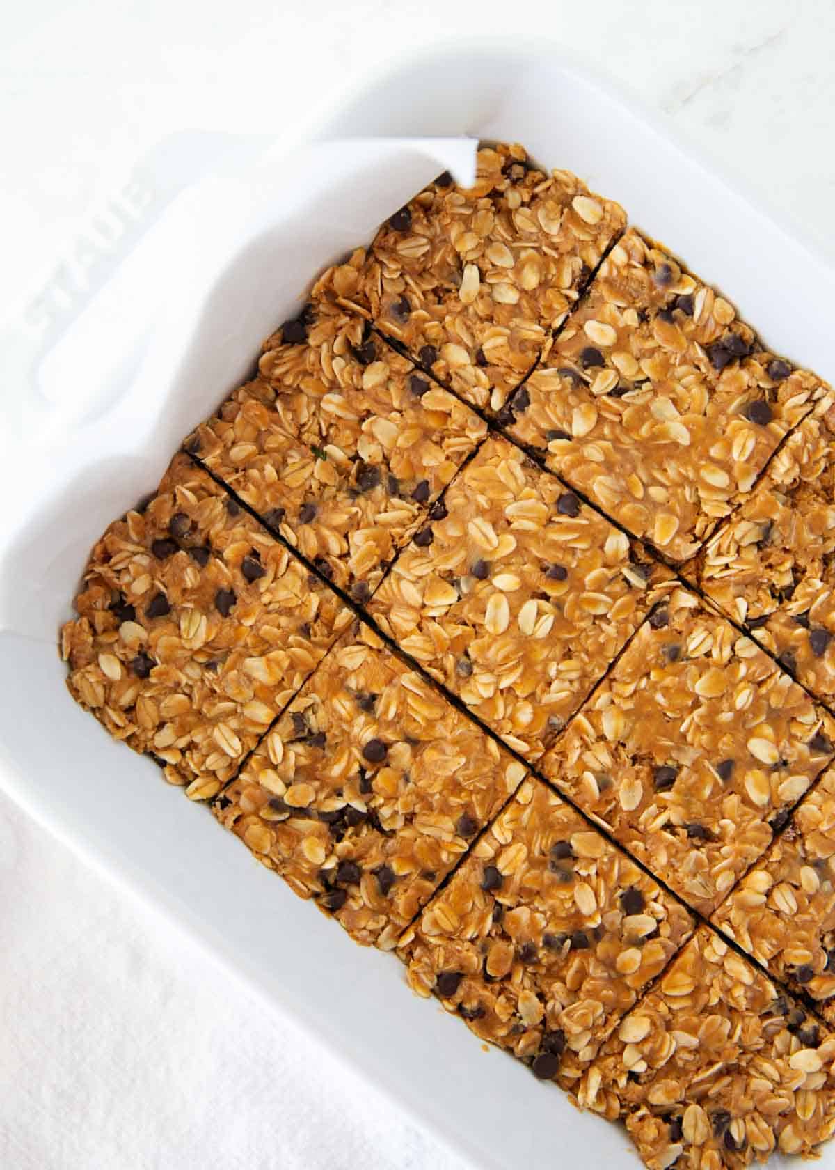 These chewy peanut butter oatmeal bars are an easy no-bake snack, breakfast or healthy dessert made with simple ingredients like peanut butter, oats, and honey! Overhead view of a full batch of no bake peanut butter oatmeal bars sliced into 12 squares.
