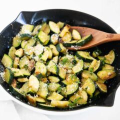 Sautéed zucchini cooked in a skillet until tender and lightly golden, then finished with olive oil, Italian seasoning, and parmesan cheese.