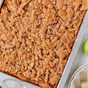 Close-up of apple slab pie in a baking pan with a crumb topping.