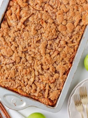 Close-up of apple slab pie in a baking pan with a crumb topping.