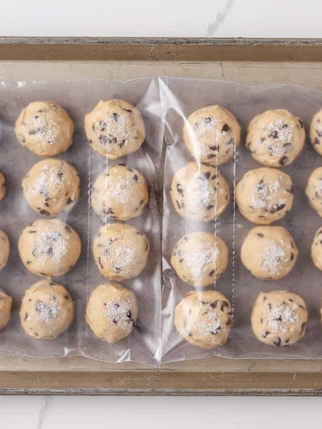Jacque Torres chocolate chip cookie dough balls sealed in a plastic bag for refrigeration, to to chill before baking.