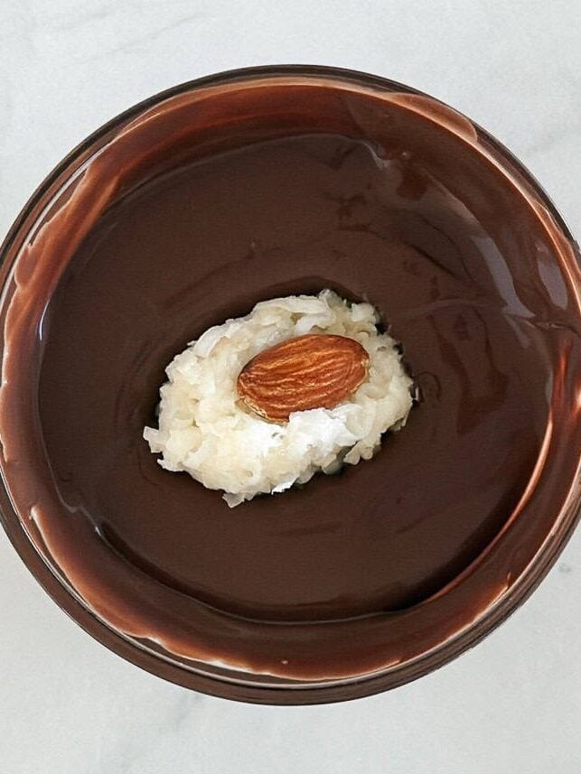 Dipping almond joy in chocolate.