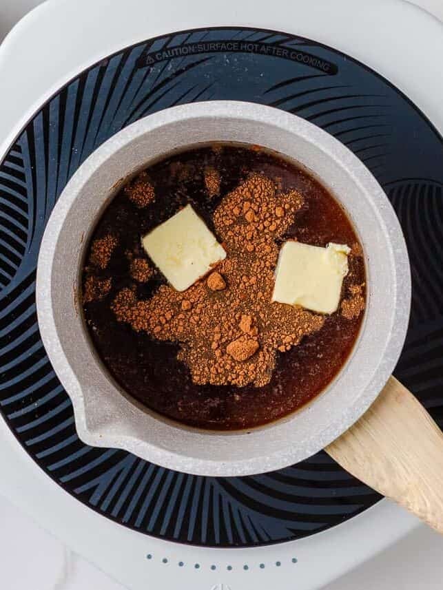 Brown sugar, cinnamon, and butter melting in a saucepan to make syrup for old fashioned apple dumplings.