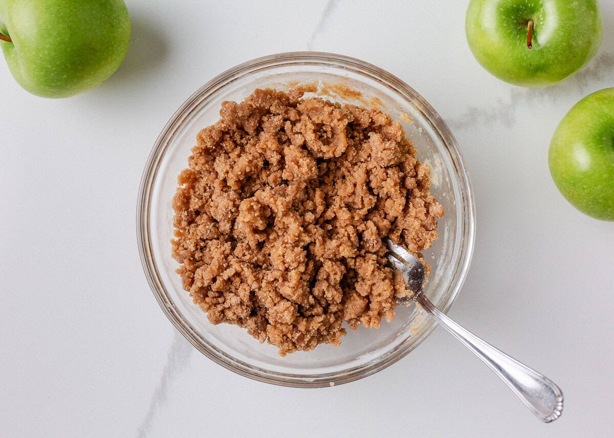 Glass bowl filled with cinnamon-sugar crumble topping.