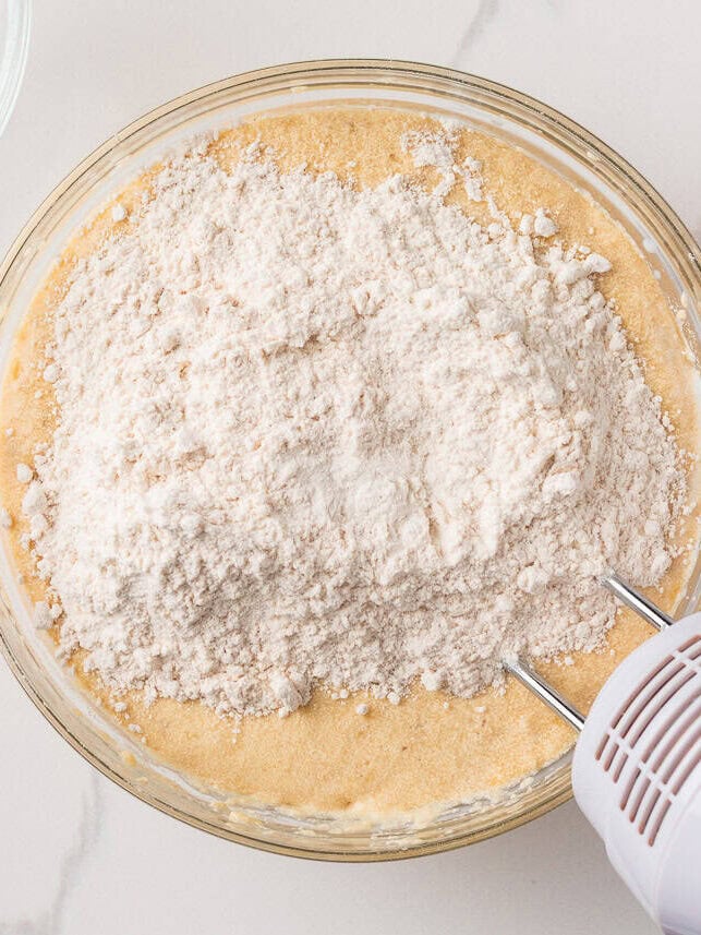 Image 3 (adding dry ingredients): Dry ingredients being added to wet banana cake batter in a bowl with an electric mixer.