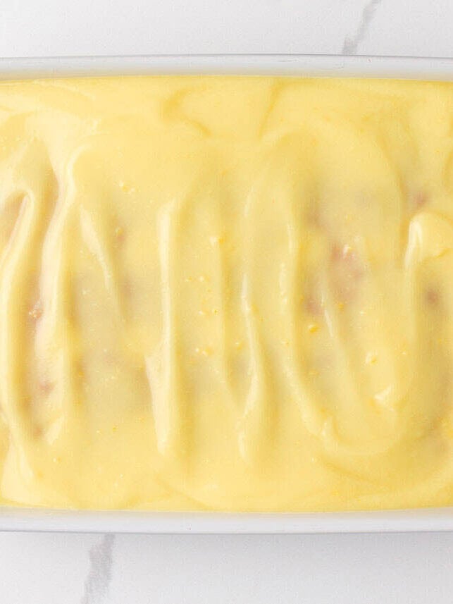 Yellow cake topped with creamy vanilla pudding layer spread evenly.