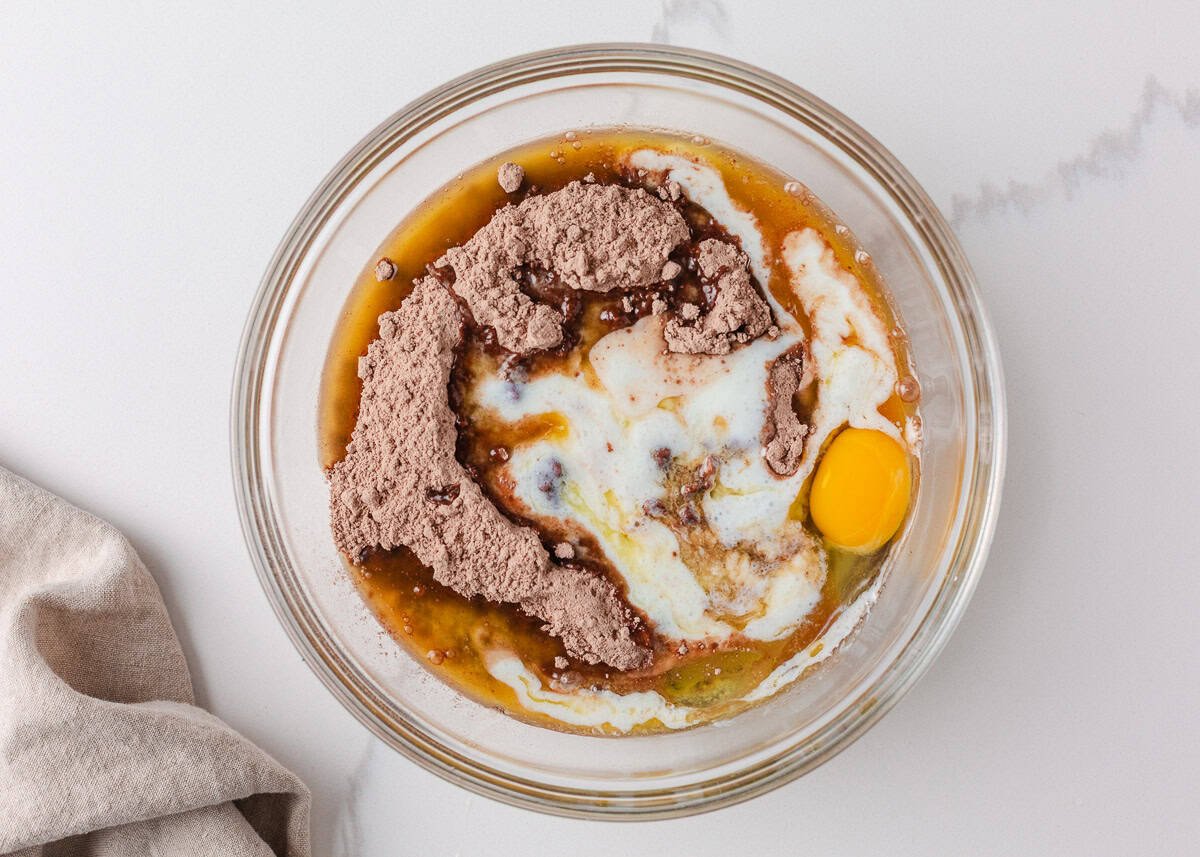 Brownie mix, milk, butter, and egg in a mixing bowl before being stirred into batter.