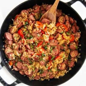 Homemade sausage and rice skillet cooked in one pot with sliced sausage, peppers, and rice.