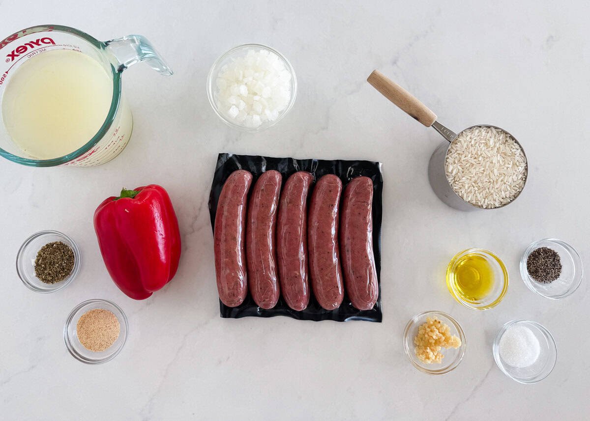 This sausage and rice skillet is the perfect one-pan dinner for busy weeknights packed with savory sausage, rice, and tender veggies! It's a hearty meal the whole family will love. Ingredients for sausage and rice skillet including Italian sausage, rice, bell pepper, onion, chicken broth, and seasonings.