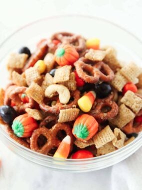 Close-up of sweet and salty fall Chex mix featuring candy pumpkins, M&Ms, and crunchy cereal