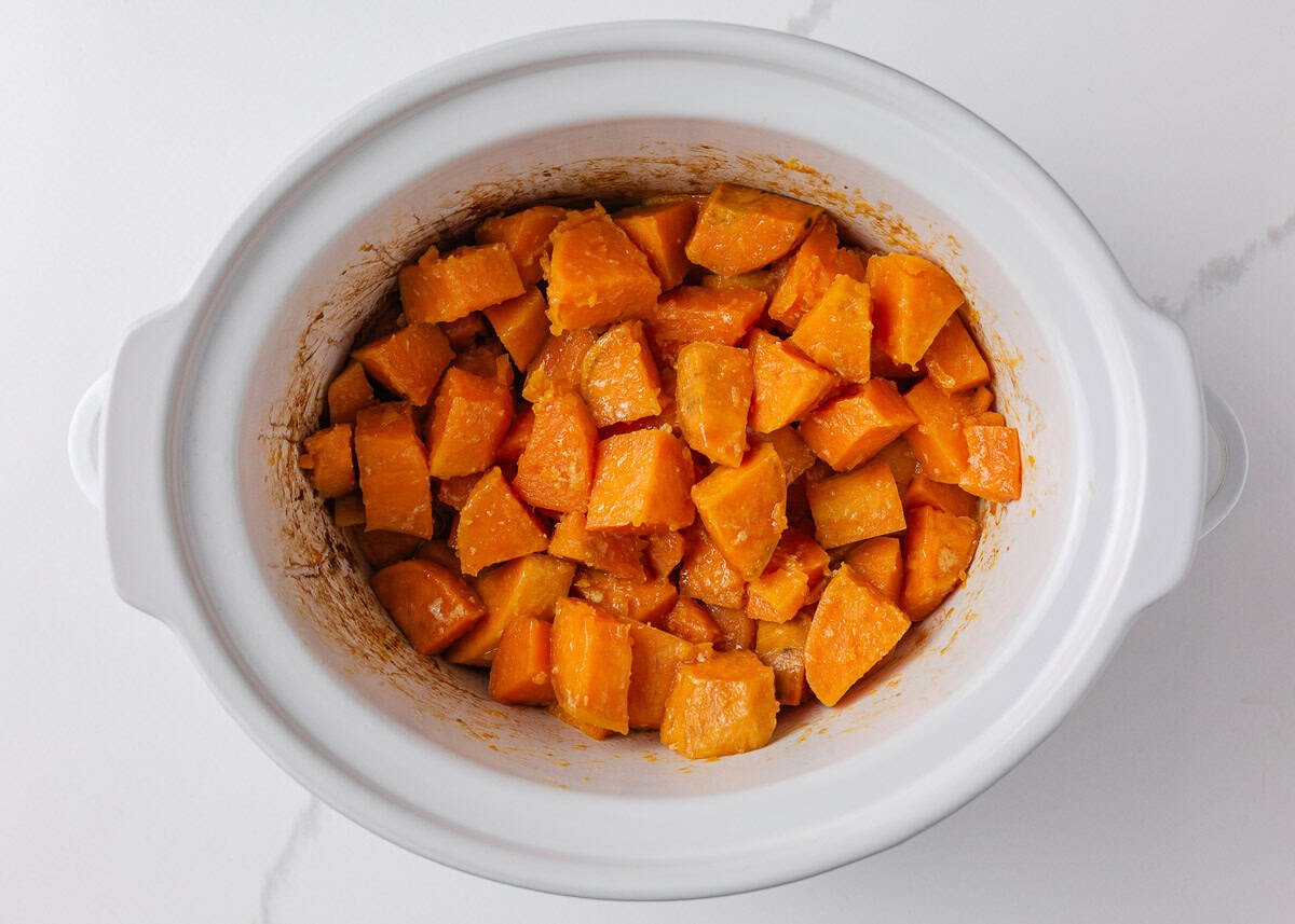 Crockpot sweet potato casserole makes holiday cooking easy. With creamy mashed sweet potatoes and a crunchy pecan topping, it's a holiday side dish not to be missed! Cubed sweet potatoes cooked in crockpot for sweet potato casserole.