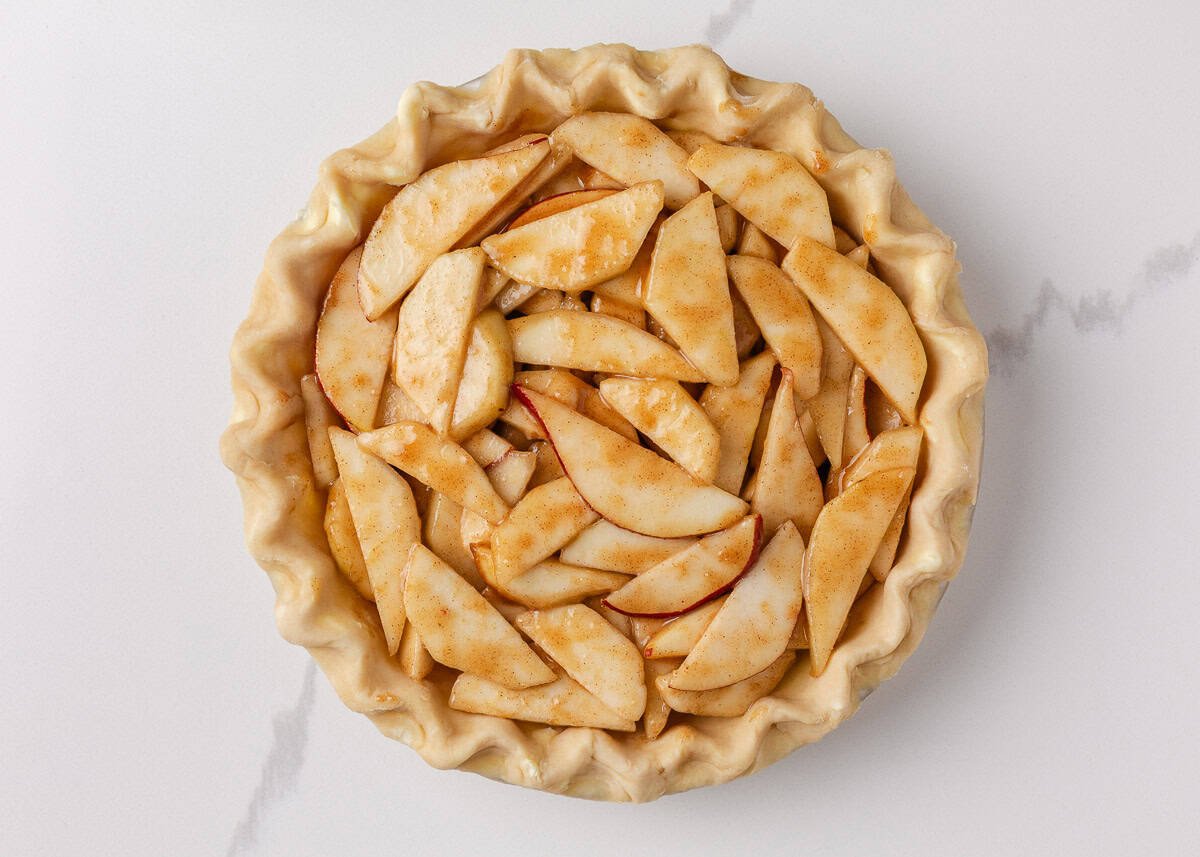 Nothing says fall like an old-fashioned pear pie! Juicy, tender pears in a flaky pastry then topped with a golden crumble are the perfect blend of sweet fruit and buttery crunch. Pie crust filled with spiced pear slices before baking.