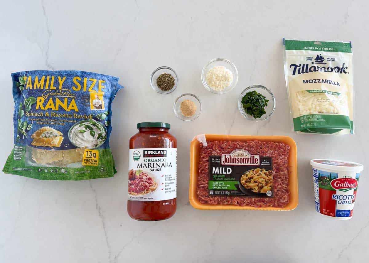 Million dollar ravioli casserole ingredients including frozen ravioli, ricotta, mozzarella cheese and marinara.