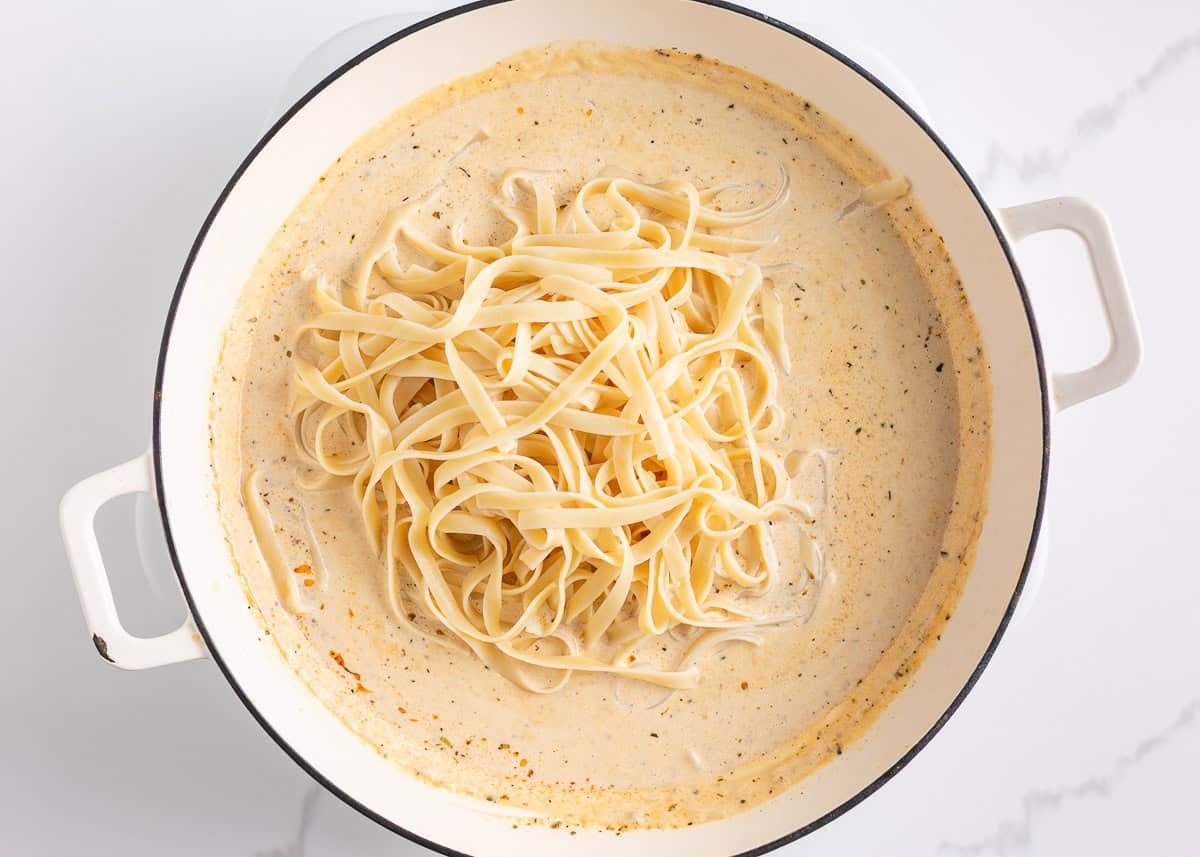 This blackened chicken Alfredo is an easy weeknight dinner that combines creamy Alfredo sauce with blackened chicken for a Southern twist on an Italian classic! Cooked fettuccine noodles added to a skillet of creamy Alfredo sauce before tossing together.