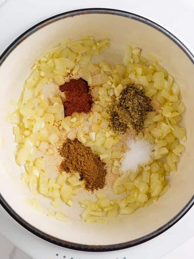 This white chicken chili is creamy, flavorful, and ready in just 30 minutes. Made with shredded chicken, white beans, and green chiles, it's great for game day or weeknights! Sautéed onions in a pot with cumin, paprika, oregano, and salt.