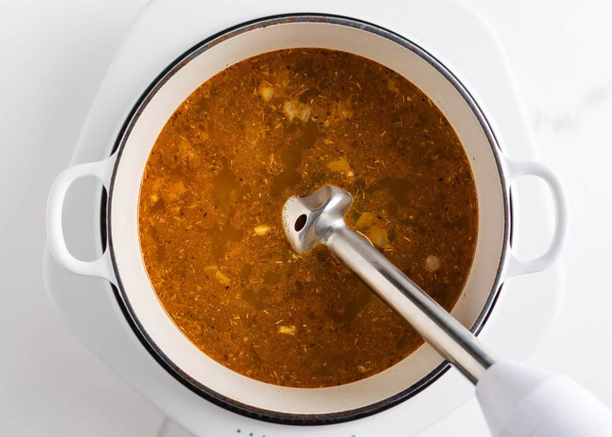 This white chicken chili is creamy, flavorful, and ready in just 30 minutes. Made with shredded chicken, white beans, and green chiles, it's great for game day or weeknights! Blending part of the white chicken chili broth with an immersion blender to thicken the soup.