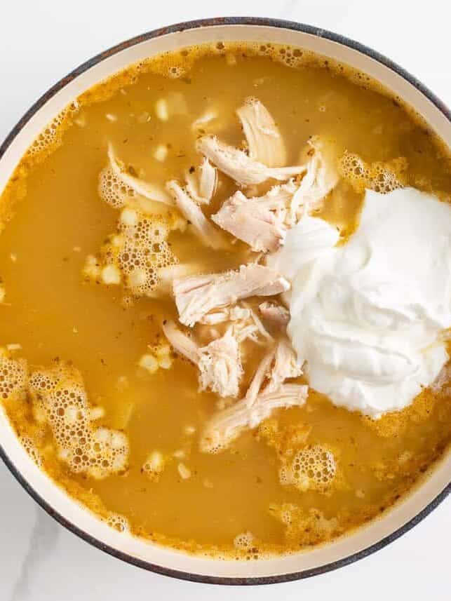 This white chicken chili is creamy, flavorful, and ready in just 30 minutes. Made with shredded chicken, white beans, and green chiles, it's great for game day or weeknights! Adding shredded chicken and sour cream to white chicken chili to make it creamy.