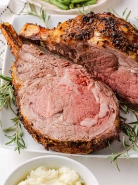 Garlic herb prime rib recipe sliced on a platter showing juicy, tender and melt-in-your mouth roast.