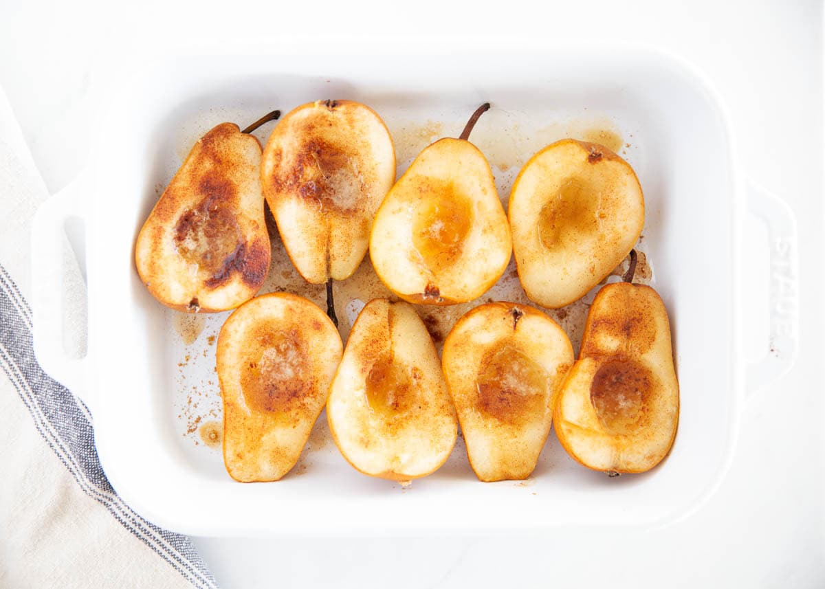 Caramelized baked pears cooling in a white dish, an easy fall dessert with pears.