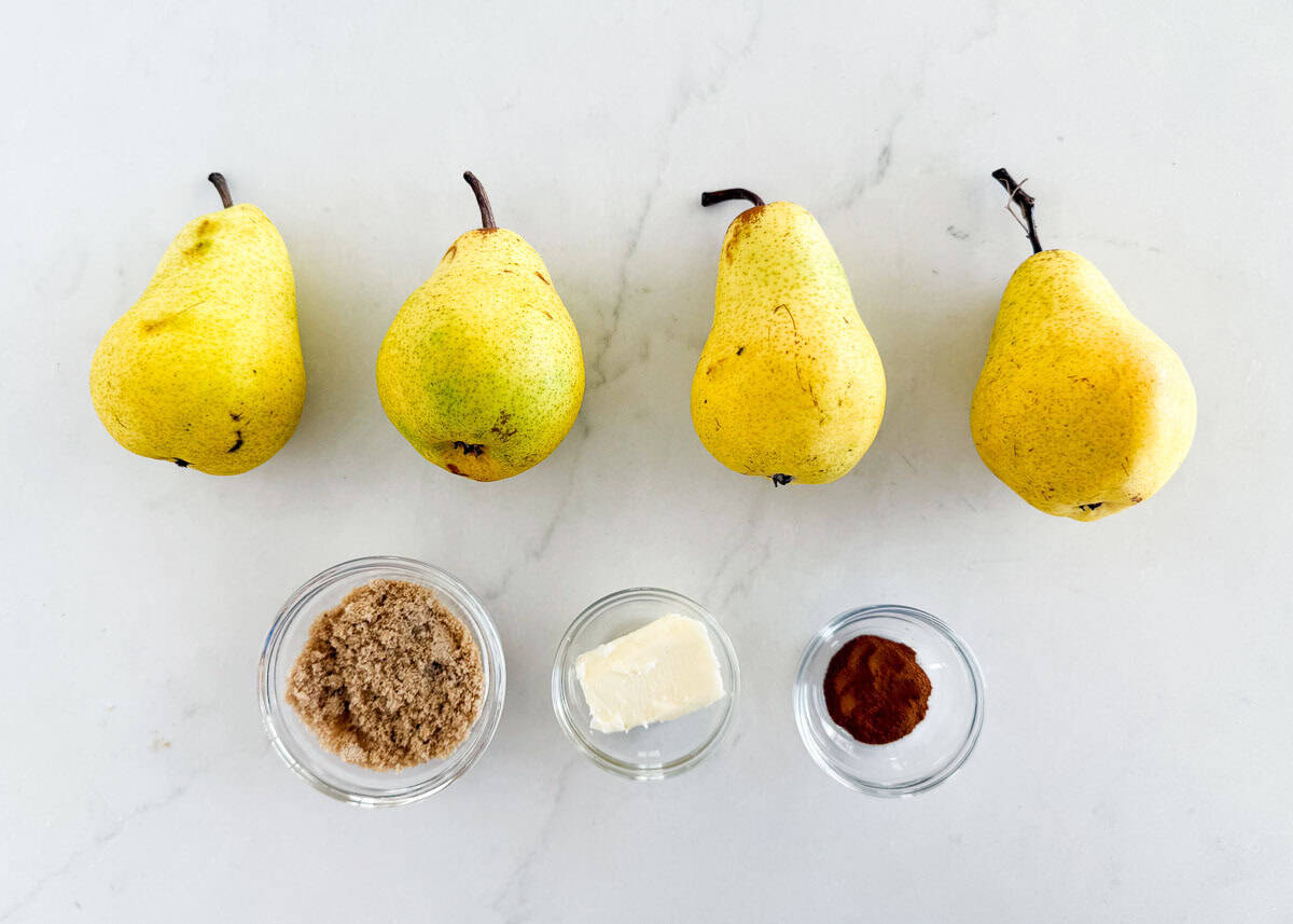 Ingredients for baked pears recipe displayed on counter: fresh pears, brown sugar, butter, and cinnamon.