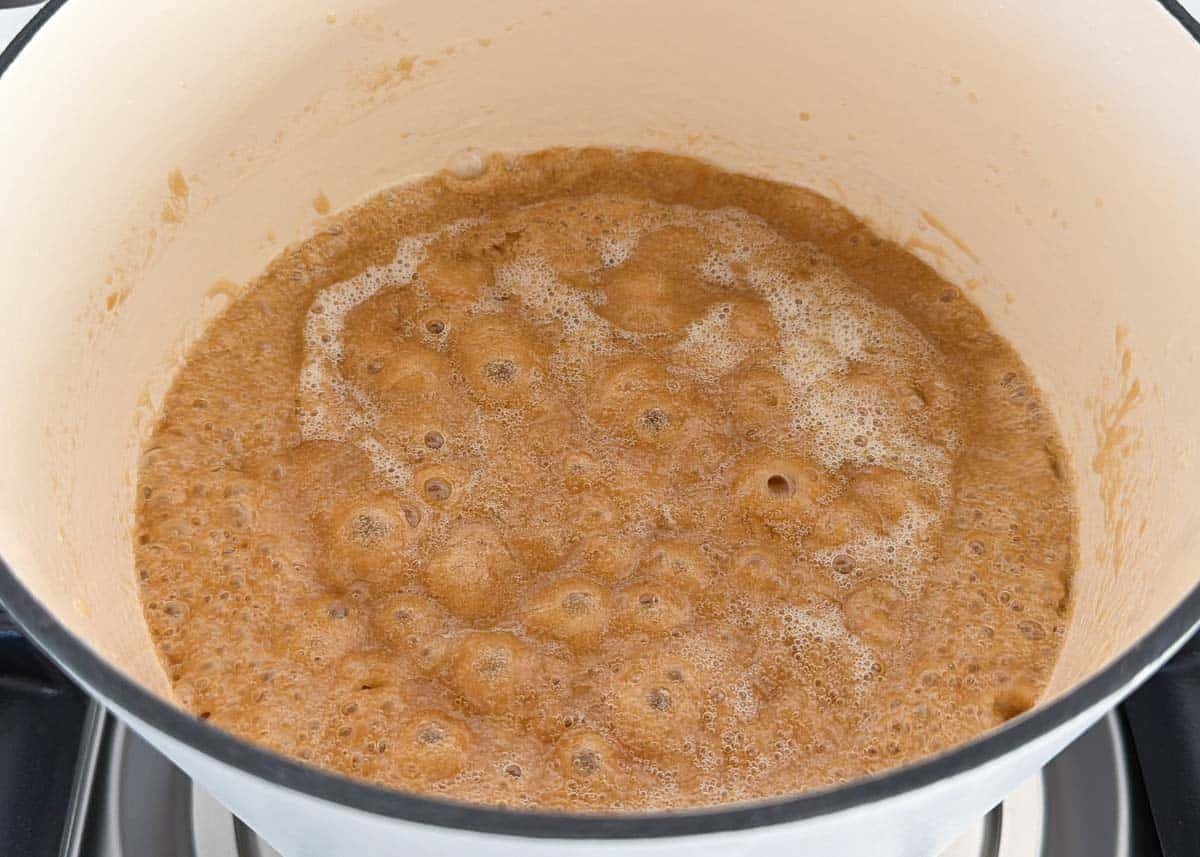 Pot of bubbling caramel mixture for churro cracker toffee.