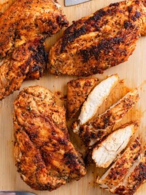 Vertical image of sliced blackened chicken showing the crisp seasoning crust and moist white meat inside.