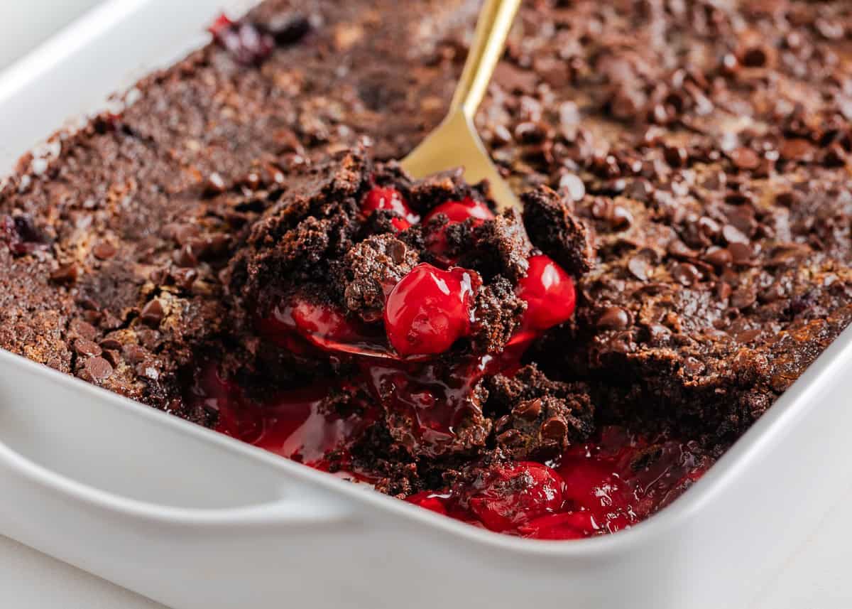 Rich, gooey, and packed with chocolate cherry flavor, this chocolate cherry dump cake is made with only 4 ingredients and minimal prep. It's a quick and easy indulgent dessert! Freshly baked chocolate cherry dump cake with gooey cherry filling and melted chocolate chips being served.