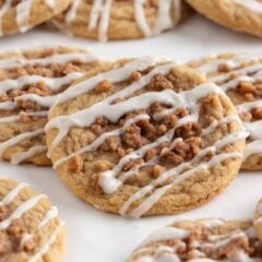 Close-up of a soft coffee cake cookie topped with cinnamon crumb and sweet glaze drizzle.