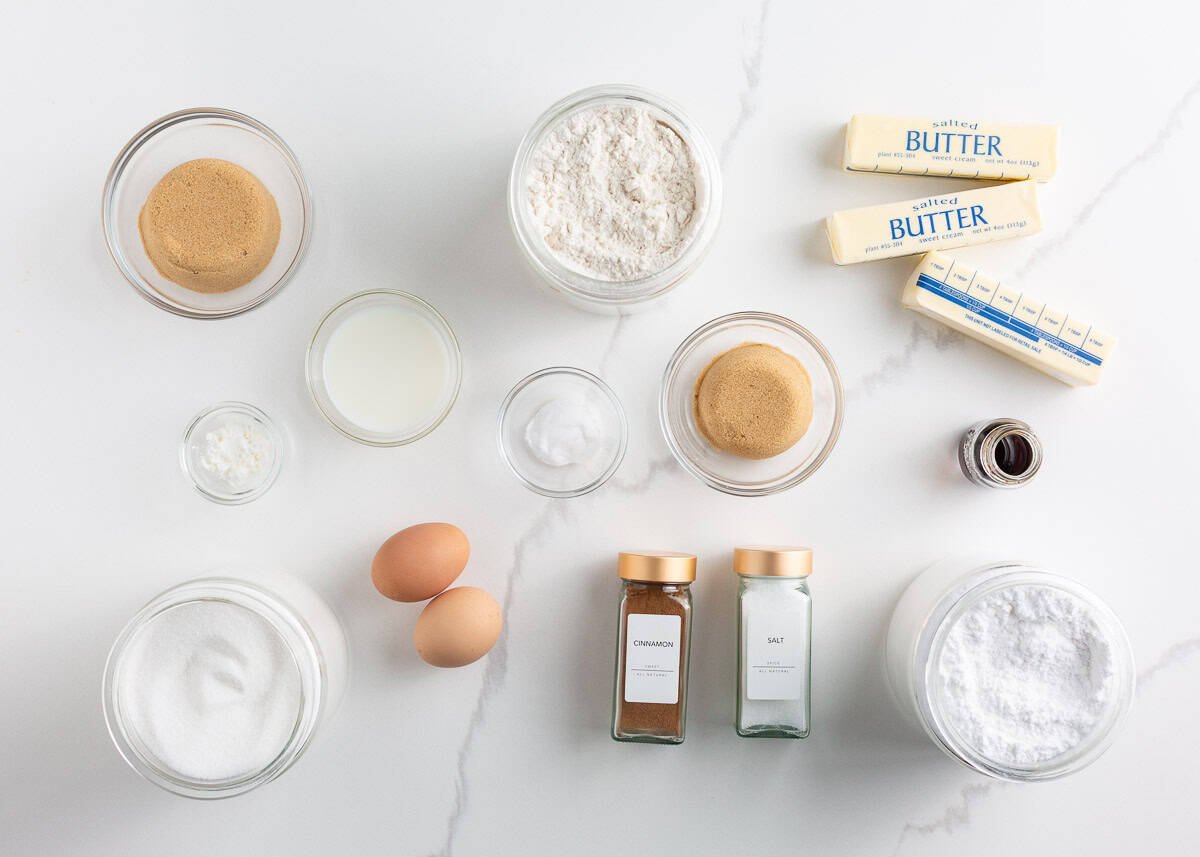 Originally inspired by The Gilmore Girls, these coffee cake cookies are made with a soft and chewy cinnamon-infused brown sugar cookie with a crumb topping and vanilla glaze! Ingredients for homemade coffee cake cookies, including butter, sugar, flour, eggs, cinnamon, and powdered sugar laid out on a countertop.