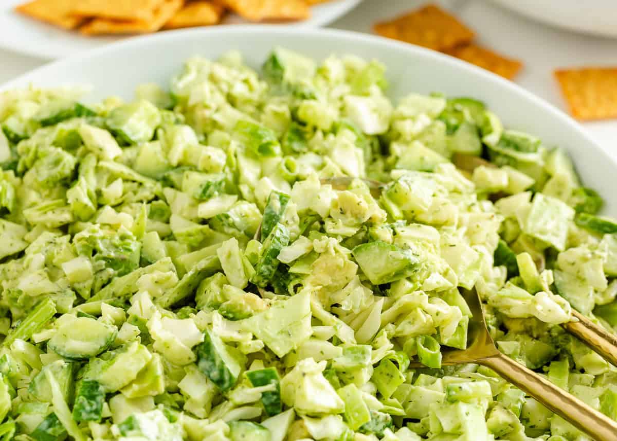 Learn to make this TikTok Green Goddess Salad with the best, most flavorful homemade green goddess salad dressing you're going to want to put on everything! Close-up of chopped green goddess salad made with cabbage, cucumbers, avocado, and green onions in a white bowl.
