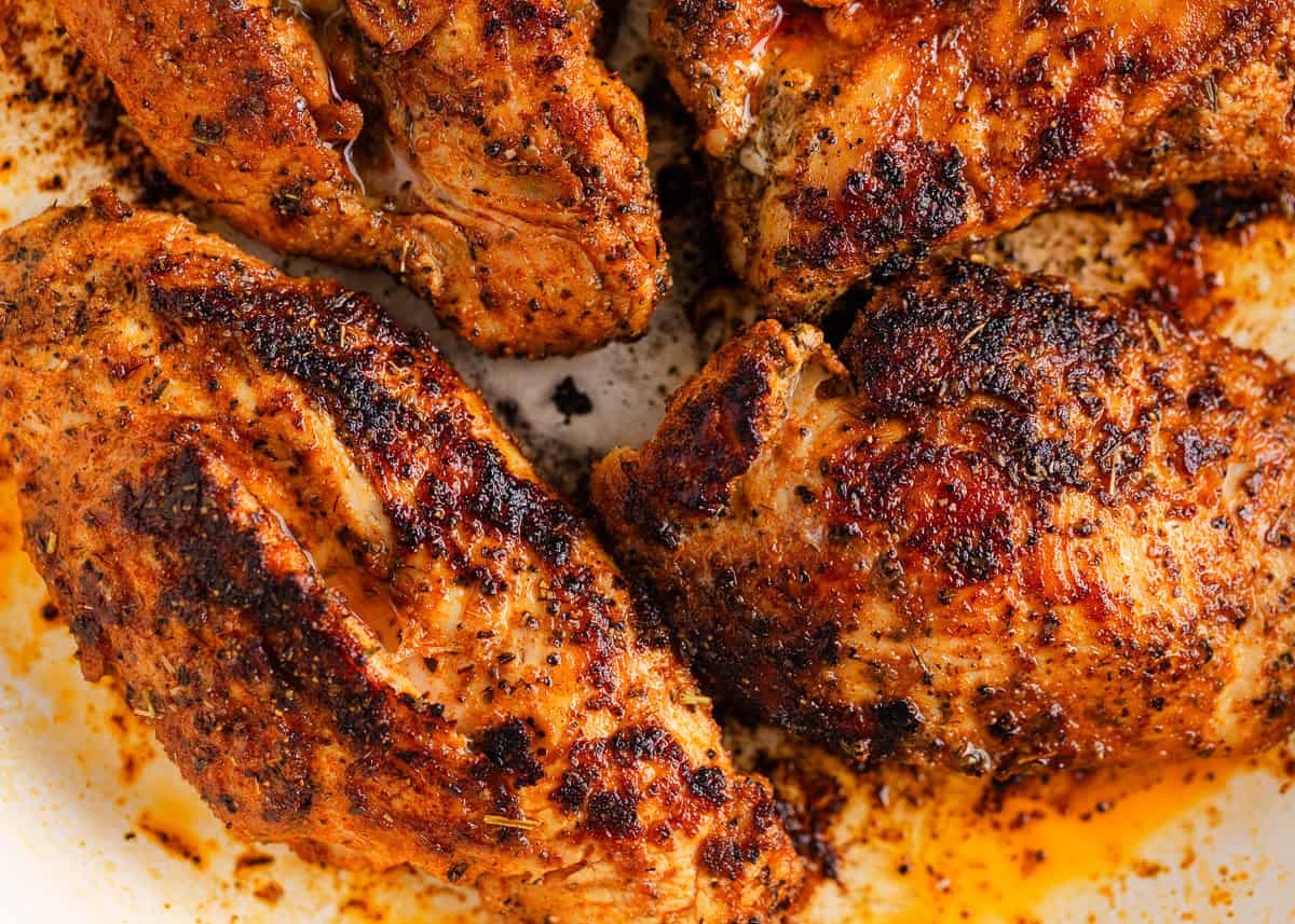 Make perfectly seasoned blackened chicken with a smoky crust and tender, juicy middle. Serve it over creamy Alfredo, rice, or salad for an easy way to add big flavor to any dinner. Close-up view of seared blackened chicken with a dark, flavorful crust and pan drippings.