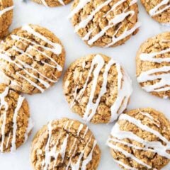 Gingerbread oatmeal cookies with vanilla glaze arranged on the countetop.