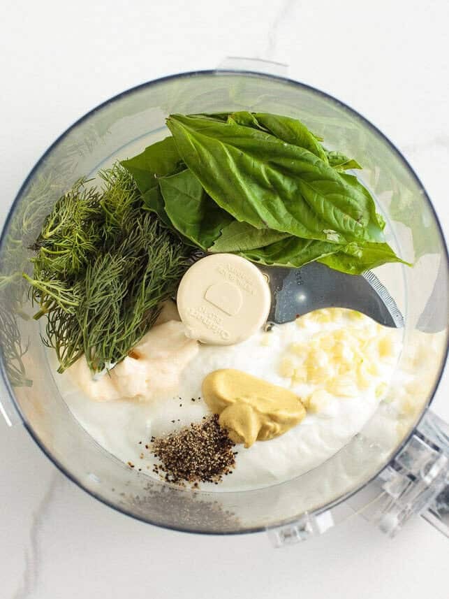 Learn to make this TikTok Green Goddess Salad with the best, most flavorful homemade green goddess salad dressing you're going to want to put on everything! Food processor filled with basil, dill, yogurt, mayo, garlic, mustard, salt, and pepper ready to blend into green goddess dressing.