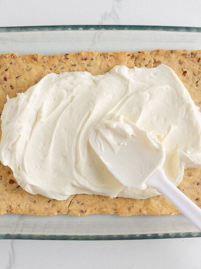 Baked pecan shortbread crust cooled in a glass baking dish, ready for the next layer.