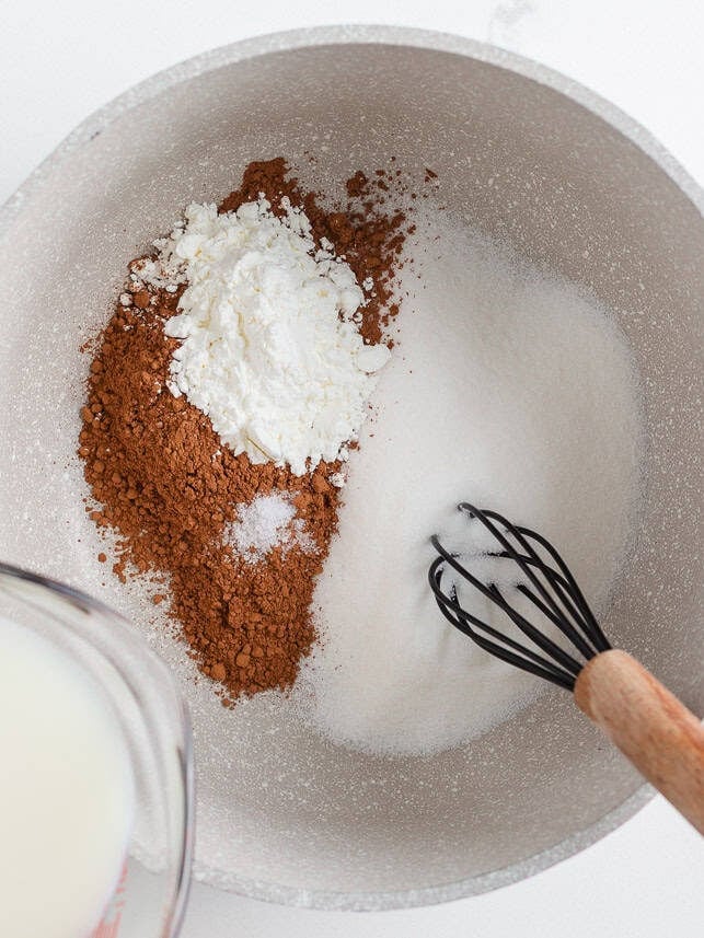 This homemade chocolate pudding is rich, creamy, and easy to make from scratch with just a few simple ingredients. It's just the treat when a chocolate craving hits! Homemade chocolate pudding ingredients whisked together in a saucepan, including sugar, cocoa powder, cornstarch, and salt.