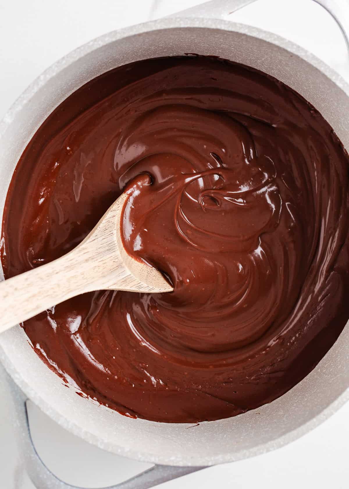 This homemade chocolate pudding is rich, creamy, and easy to make from scratch with just a few simple ingredients. It's just the treat when a chocolate craving hits! Homemade chocolate pudding cooked until thick and glossy in a saucepan with a wooden spoon.