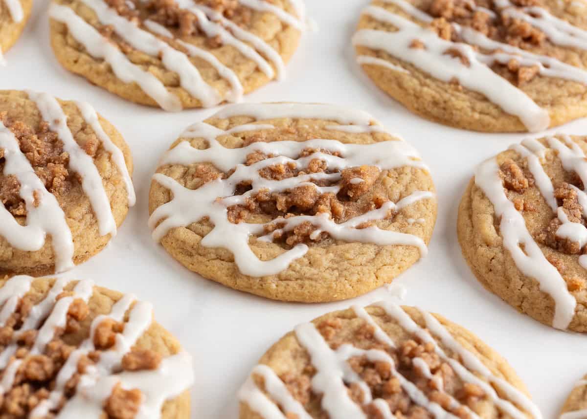Originally inspired by The Gilmore Girls, these coffee cake cookies are made with a soft and chewy cinnamon-infused brown sugar cookie with a crumb topping and vanilla glaze! Soft coffee cake cookies topped with cinnamon crumb and drizzled vanilla glaze.