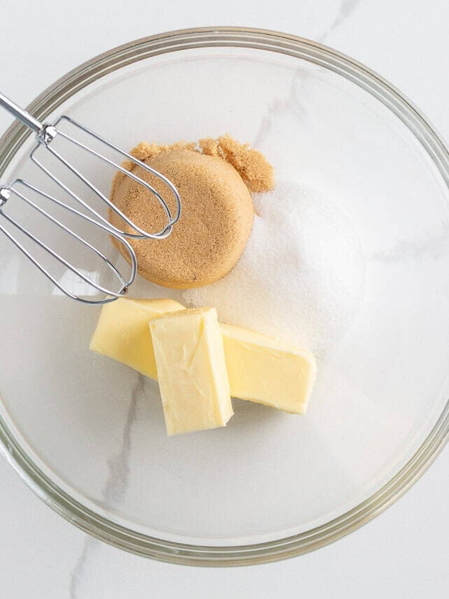 Originally inspired by The Gilmore Girls, these coffee cake cookies are made with a soft and chewy cinnamon-infused brown sugar cookie with a crumb topping and vanilla glaze! Softened butter, granulated sugar, and brown sugar in a bowl before creaming for coffee cake cookies.