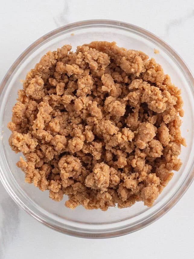 Originally inspired by The Gilmore Girls, these coffee cake cookies are made with a soft and chewy cinnamon-infused brown sugar cookie with a crumb topping and vanilla glaze! Cinnamon brown sugar crumb topping mixed together for coffee cake cookies.