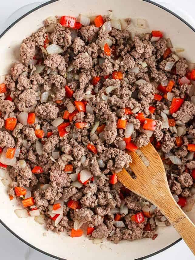 Asian-inspired ground beef lettuce wraps are easy, satisfying, and better than takeout with a juicy, sweet and spicy filling wrapped in crisp butter leaves and ready in 15 minutes. Ground beef, onions, and red bell peppers browning together in a skillet during the first step of making lettuce wraps.