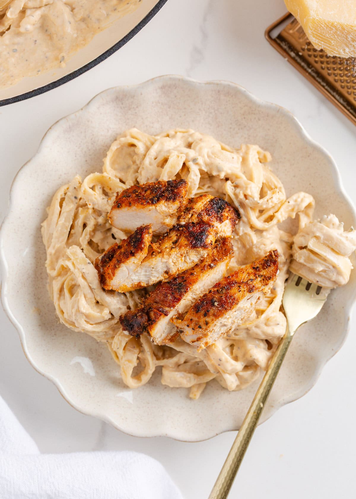 This blackened chicken Alfredo is an easy weeknight dinner that combines creamy Alfredo sauce with blackened chicken for a Southern twist on an Italian classic! Blacked chicken Alfredo on a plate.