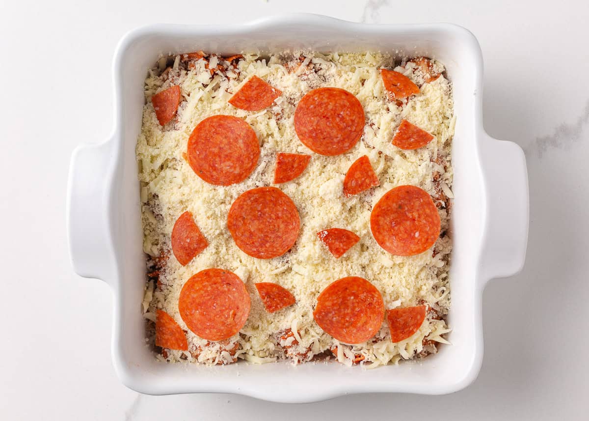 This bubble pizza is an easy way to make pizza at home without the hassle of rolling out dough. Baked into a fun pull-apart style, it’s packed with crowd-pleasing pizza flavor! Unbaked pepperoni bubble pizza topped with mozzarella, Parmesan, and sliced pepperoni in a baking dish.