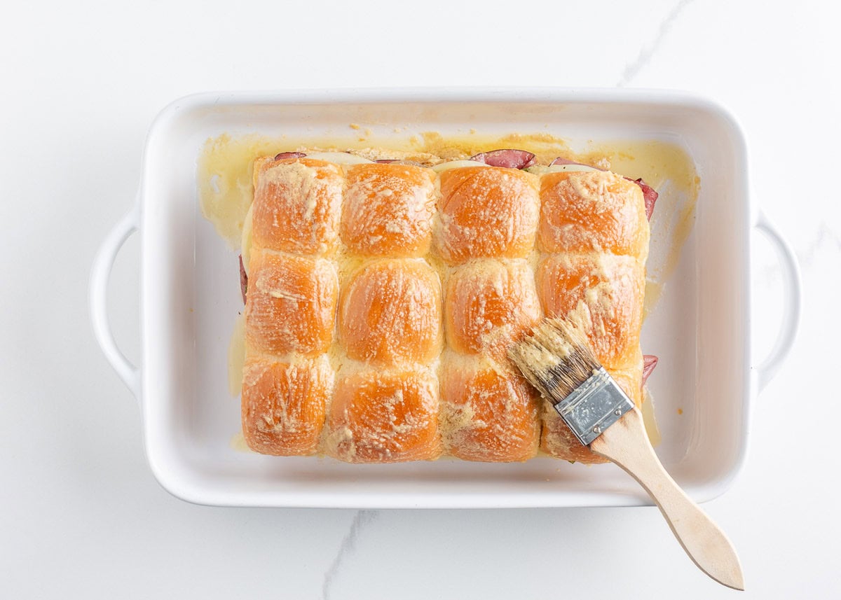 Philly cheesesteak sliders made with Hawaiian rolls stuffed with roast beef, sautéed peppers and onions, and melty cheese. A crowd-pleasing mini version of the classic! Hawaiian rolls brushed with melted butter and seasonings before baking Philly cheesesteak sliders.