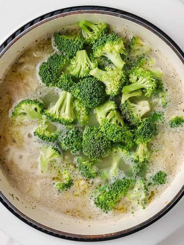 Comforting, easy to make, and packed with flavor, a bowl of this broccoli cheese and potato soup is perfect for cozy dinners! Fresh broccoli florets added to the pot to cook for broccoli cheese and potato soup.