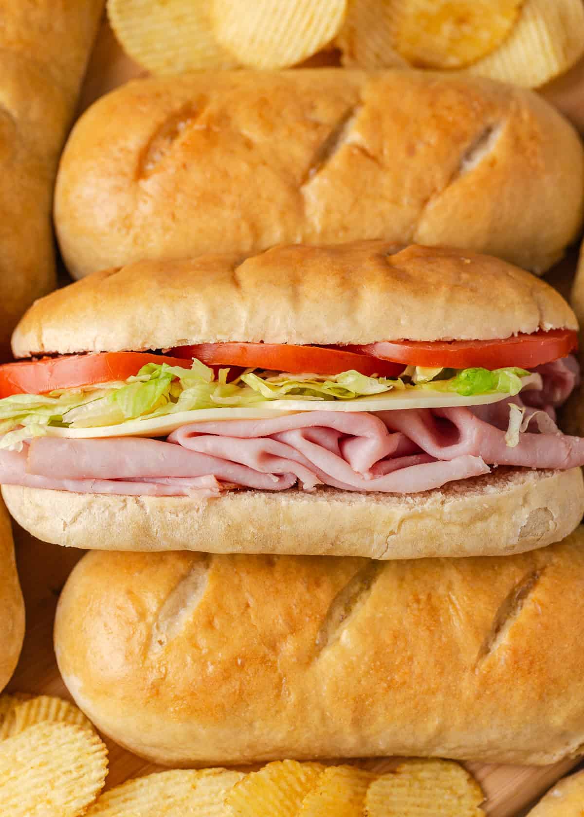Soft on the inside with a golden, chewy crust, these homemade hoagie rolls are easy to make and instantly upgrade your favorite subs and sandwiches. Hoagie sandwich made with homemade hoagie rolls, deli meat, cheese, lettuce, and tomato.