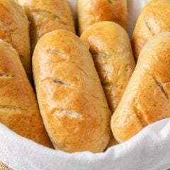 Freshly baked homemade hoagie rolls in a lined basket.