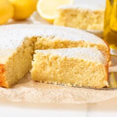 Moist lemon olive oil cake slice showing tender crumb, dusted with powdered sugar.